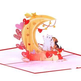3D pop-up card featuring a white cat and beagle puppy sitting on a crescent moon with red hearts